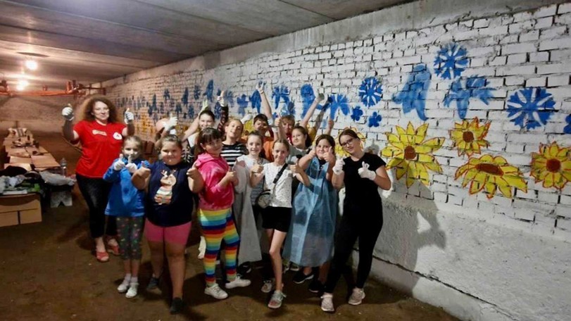 Ett gäng barn målar väggarna i en skolas skyddsrum i staden Lviv.