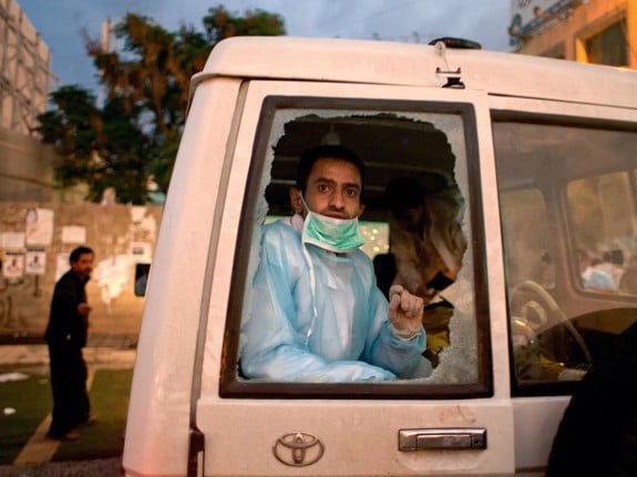 Man i ambulans ser ut genom krossat fönster