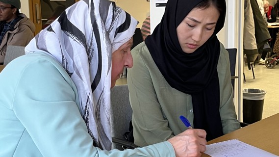 Firdows Hassan hjälper Sakina Rezaie med den svenska grammatiken på Röda Korsets språkkafé.